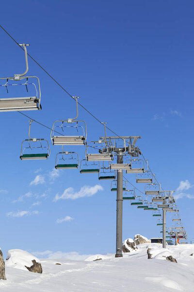 Chair-lift and snowy slope at ski resort on sun day. Caucasus Mountains in winter, Shahdagh, Azerbaijan.