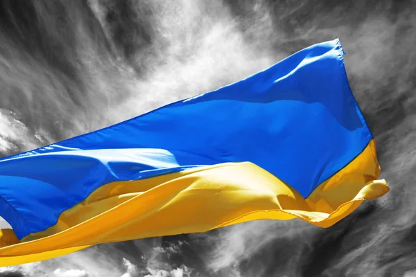 stock image Sunlight flag of Ukraine waving on black and white storm sky at sun windy day