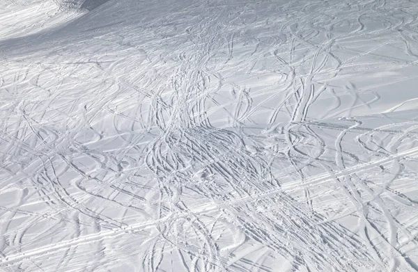 阳光明媚的冬夜 滑雪板和雪板上留下痕迹的雪地滑雪坡 — 图库照片