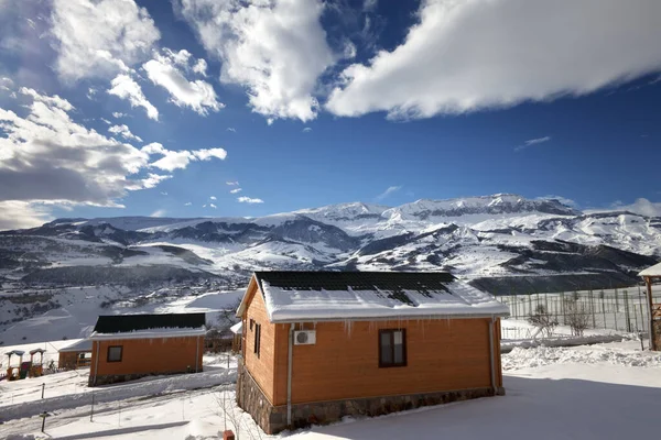 Kleine Houten Huisjes Besneeuwde Winterbergen Blauwe Lucht Met Wolken Kaukasus — Stockfoto