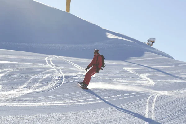 Snowboarder Vermelho Desce Pista Esqui Nevado Preparado Pela Máquina Aliciamento — Fotografia de Stock