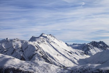 Karlı yüksek kış dağları ve güzel bulutlu güneşli gökyüzü. İtalyan Alpleri. Levigno, Lombardiya bölgesi, İtalya, Avrupa.