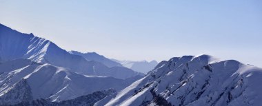 Panoramic view on snowy high mountains in early morning. Caucasus Mountains. Georgia, region Gudauri at winter.