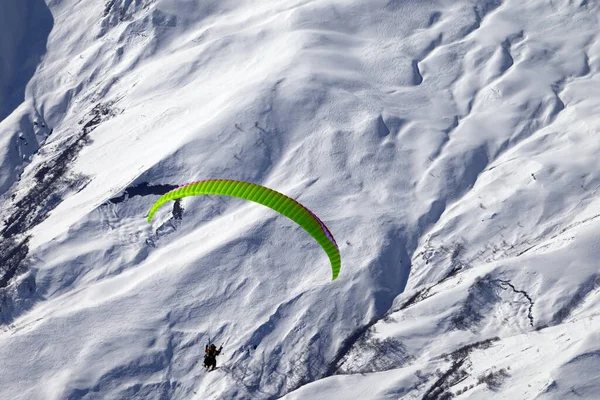 晴れた冬の日に雪の多い高い山でスピード飛行 ストックフォト
