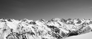 Panorama of snow covered mountains with mount Elbrus at background. View from region Dombay, Caucasus Mountains in winter. Black and white toned landscape.