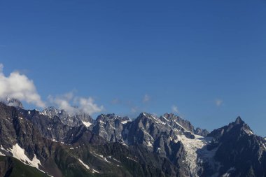 Sunlit high mountains with snow and glacier. Caucasus Mountains. Georgia, region Svanetia in summer. 