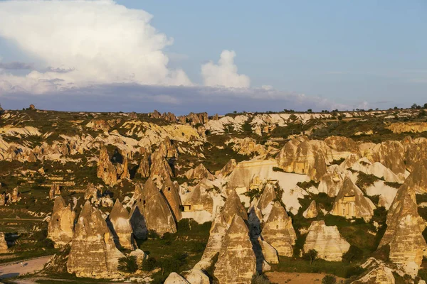View on evening sunlit Cappadocia valley with cave houses in rocks in spring. Turkey, Goreme.