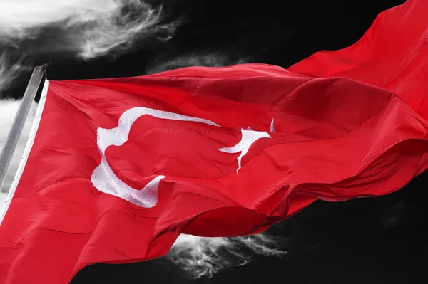 Flag of Turkey waving against black and white dark windy sky. Close-up view.