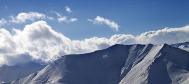 Karlı pistte panoramik manzara ve akşamları bulutlu güneşli gökyüzü. Gürcistan, Gudauri bölgesi. Kışın Kafkas Dağları. 