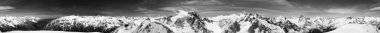 Black and white cylindrical panorama 360 degrees of high snow-capped mountain peaks and beautiful sky with clouds at sunny day. Caucasus Mountains in winter, region Dombay.