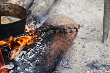 Yanan gitar boynu ve ormanda kamp ateşinde eski bir kazan.