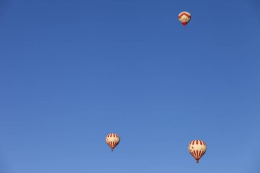 GOREME, CAPPADOCIA, TURKEY - MAYIS, 2013: Güneşli sabahlarda açık mavi gökyüzünde Türkçe sembolik sıcak hava balonları