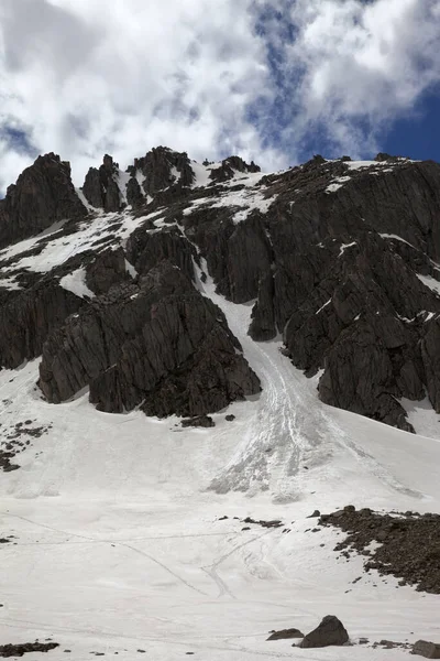 Ψηλά Χιονισμένα Βράχια Ίχνη Από Χιονοστιβάδα Και Ηλιόλουστο Συννεφιασμένο Ουρανό — Φωτογραφία Αρχείου