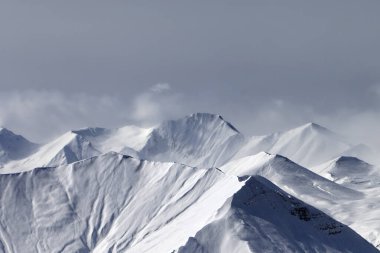 Gri günde bulutlu gökyüzü ve sisli kış dağları. Kafkasya Dağları, Gürcistan, Gudauri bölgesi.