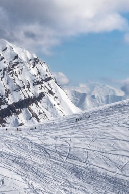Güneşli kış gününde kayak, snowboard ve freerider siluetinden izler taşımak için karlı bir iniş pisti. Kafkasya Dağları, Gürcistan, Gudauri bölgesi.