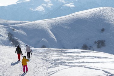 Kayakçılar ve snowboardcular kış sabahı karlı yolda. Kafkasya Dağları, Gürcistan, Gudauri bölgesi.