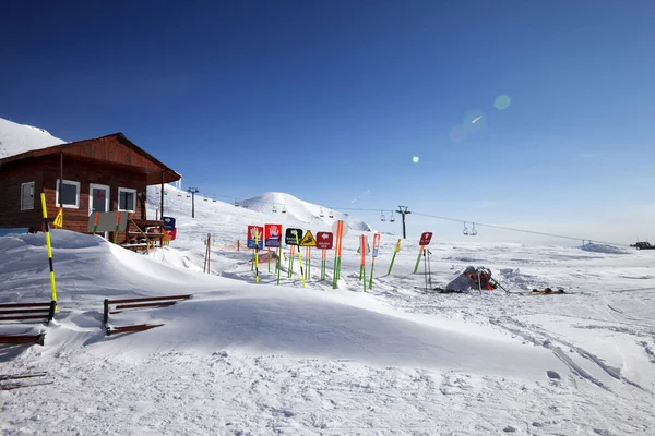 Wysokie Góry Śnieżne Drewniany Dom Ratowniczy Znaki Ostrzegawcze Zaspie Śnieżnej — Zdjęcie stockowe