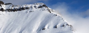 Güneşli bir günde sisli, karlı güneş ışığı dağlarının panoramik manzarası. Kışın Kafkasya Dağları, Gürcistan, Gudauri bölgesi.