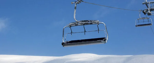 雪地的滑雪场 滑雪场的椅子升降 下雪天的蓝天 高加索山脉 格鲁吉亚 地区Gudauri在冬季 全景视图 — 图库照片