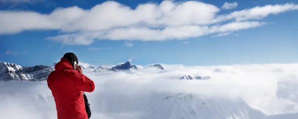 滑雪者站在山顶上 在手机上说话 雪山在雾中 高加索山脉在冬日的阳光下 格鲁吉亚 古道里地区 全景视图 — 图库照片
