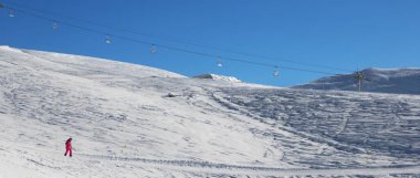 Kar kayaklı yamaçta kar kayakçısı soğuk güneş sabahında. Gürcistan, Gudauri bölgesi. Kışın Kafkas Dağları. Panoramik görünüm