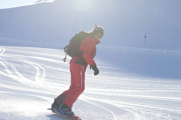 Snowboarder Red Descends Snowy Ski Slope Prepared Grooming Machine Sun — Stock Photo, Image