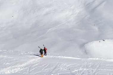 Omzunda kayak izleri ve kayak ve snowboard izleri olan iki kayakçı. Kafkasya Dağları güneş altında soğuk kış günü, Gürcistan, Gudauri bölgesi.