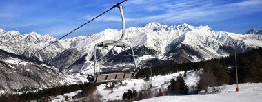 Güneşli bir günde karlı kış dağlarında kayak yamacı ve sandalye kaldırma. Kafkas Dağları. Hatsvali, Gürcistan 'ın Svaneti bölgesi. Panoramik görünüm.