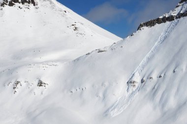 Kayak, snowboard ve çığ izleri olan kar pisti yokuş yukarı. Güneşli kış gününde Kafkasya Dağları, Gürcistan, Gudauri bölgesi.