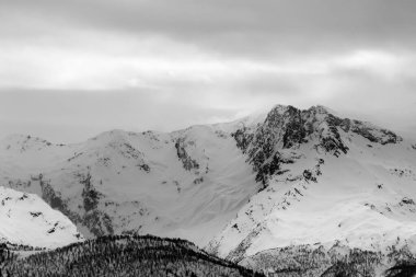Kar fırtınasından önce karlı dağlar ve gri bulutlu gökyüzü. Kışın Kafkas Dağları. Gürcistan 'ın Svaneti bölgesi. Siyah ve beyaz tonlu manzara.