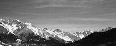 Güneşli bir sabahta karlı dağların panoramik manzarası. Kışın Kafkas Dağları. Gürcistan 'ın Svaneti bölgesi. Siyah ve beyaz tonlu manzara.