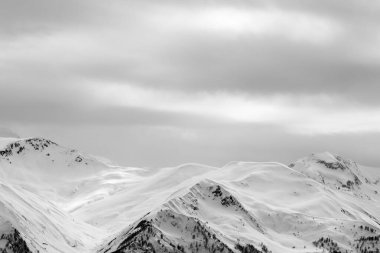 Kar fırtınasından önce sisli ve gri bulutlu güneş ışığı dağları. Kışın Kafkas Dağları. Gürcistan 'ın Svaneti bölgesi. Siyah ve beyaz tonlu manzara.