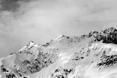 Kış akşamı sisli ve bulutlu gökyüzünde karlı dağlar. Kafkas Dağları. Gürcistan 'ın Svaneti bölgesi. Siyah ve beyaz tonlu manzara.