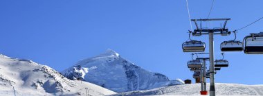 Güneşli bir sabahta kayak merkezinde kayak kaldırma. Kışın Karlı Kafkasya Dağları. Tetnuldi Dağı, Gürcistan 'ın Svaneti bölgesi. Panoramik görünüm.