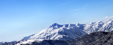 Güneşli sabahın erken saatlerinde karlı dağlar ve mavi gökyüzü. Kışın Kafkas Dağları. Gürcistan 'ın Svaneti bölgesi. Panoramik görünüm.