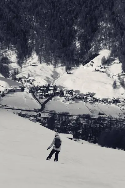 Snowboardista Zasněžené Sjezdovce Vysokých Zimních Horách Sluncem Zalité Vesnici Pozadí — Stock fotografie