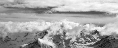 Güzel bir kış akşamında, güneş ışığı bulutlarında, siyah ve beyaz karlı dağlar. Kafkas Dağları. Gürcistan 'ın Svaneti bölgesi. Panoramik görünüm.