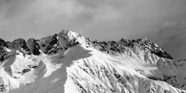 Karlı güneş ışığı dağında siyah ve beyaz panoramik manzara ve kış akşamları bulutlu gökyüzü. Kafkas Dağları. Gürcistan 'ın Svaneti bölgesi.