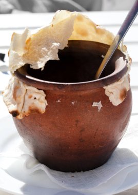 Güneşli bir günde açık kafede ekmeğe bulanmış kil çömlek.