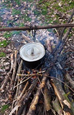Glade 'de kamp ateşinde eski, ıslak bir kazanda yemek pişirmek. Yukarıdan görüntüle.