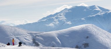 Kar kayakçıları ve snowboardcular yokuş aşağı inmeden önce. Kafkasya Dağları, Gürcistan, bölge Gudauri, güneşli kış sabahı. Panoramik görünüm.