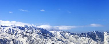 Güneş ışığında panoramik manzara karlı dağlar ve kış güneşinde bulutlu mavi gökyüzü. Kafkas Dağları. Gürcistan, bölge Svaneti.