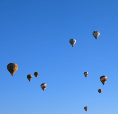 GOREM, CAPPADOCIA, TURKEY - MAYIS 07, 2013: Mavi açık güneş ışığı gökyüzünde bir sürü çok renkli sıcak hava balonu