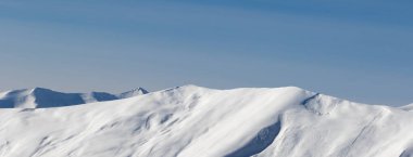 Güneş battığında çığ yüzünden oluşan karlı güneş ışığı yamacının panoramik görüntüsü. Kafkasya Dağları, Gürcistan, Gudauri bölgesi kışın.