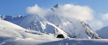 Kar yamacındaki panoramik manzarada kış akşamları kayak, snowboard ve otelden izler var. Kafkas Dağları. Gürcistan, bölge Gudauri.