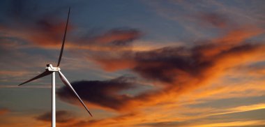 Rüzgar türbini ve günbatımı çok renkli gökyüzü. Panoramik görünüm.