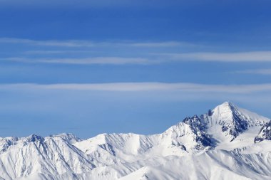 Yüksek karlı dağlar ve soğuk kış gününde bulutlu mavi gökyüzü. Kafkasya Dağları, Gürcistan bölgesi Gudauri.