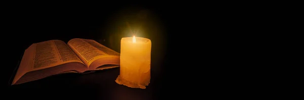 Βίβλος Στο Τραπέζι Υπό Φως Ενός Κεριού — Φωτογραφία Αρχείου