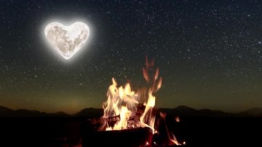 Şenlik ateşi geceleri parlak yıldızlarla dağların ve denizin arka planında yanar.