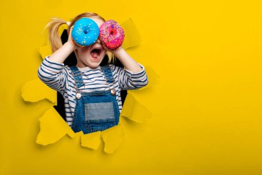 Mutlu tatlı kız siyah arka plan duvarında çöreklerle oynayarak eğleniyor.. 